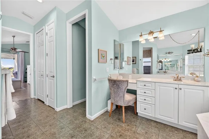 Vanity featuring extensive countertop space, double-door cabinetry, and an integrated makeup area