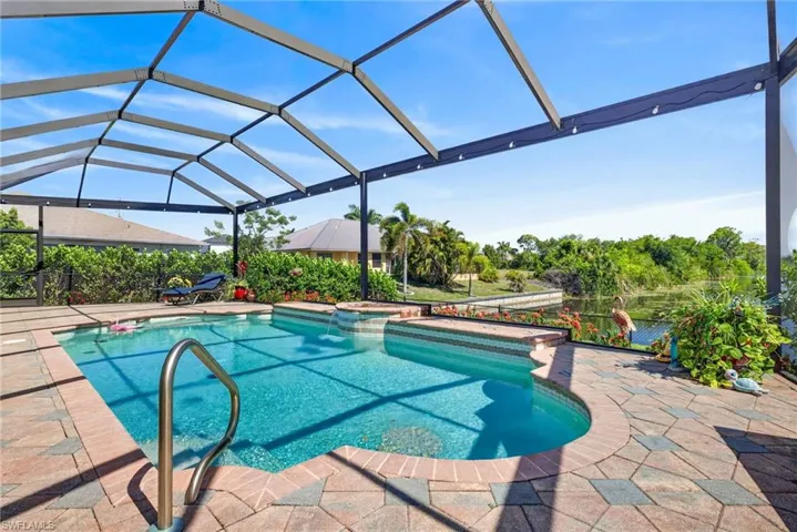 Screened pool enclosure featuring a pool and integrated spa