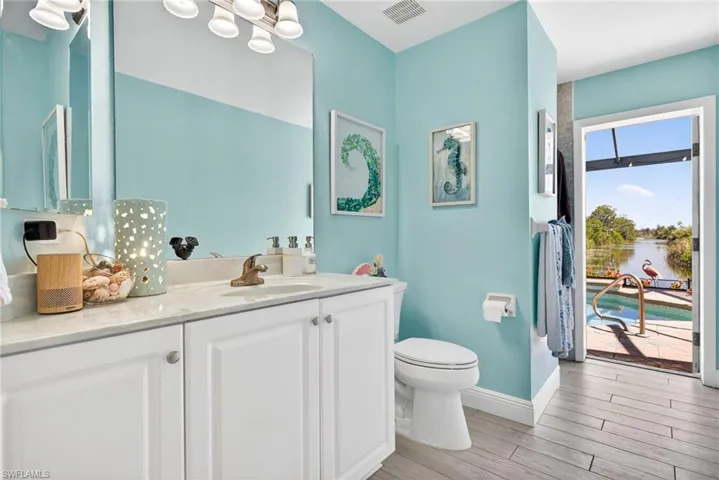 Bathroom with white vanity, integrated sink, and light-colored countertop