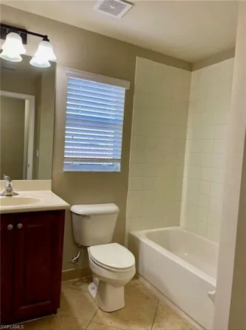 Bathroom with vanity, light tile patterned floors, and shower / bath combination