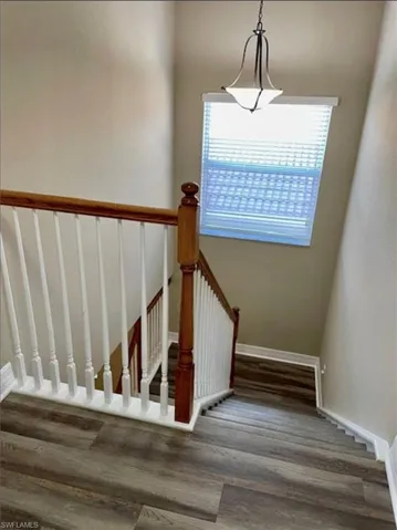 Staircase with wood finished floors and baseboards