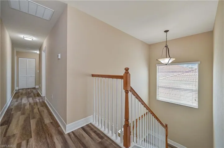 Interior staircase with wood-finish railing and white balusters
