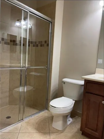 Bathroom featuring vanity, a stall shower, and light tile patterned floors