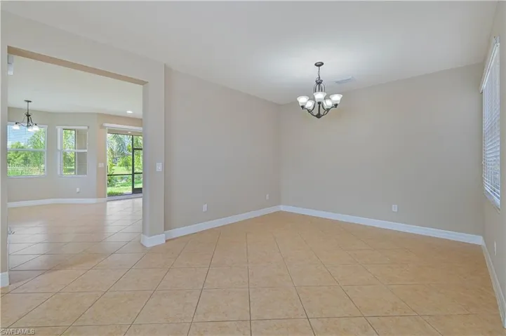 Neutral wall paint throughout, tile flooring, and a contemporary five-light chandelier