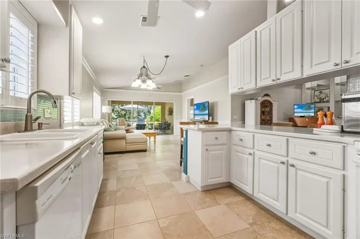 Kitchen featuring open floor plan, white cabinets, recessed lighting, white dishwasher, and a chandelier