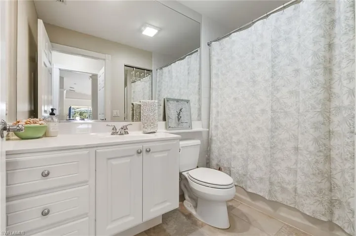 Full bathroom with vanity, shower / tub combo, and light tile patterned floors