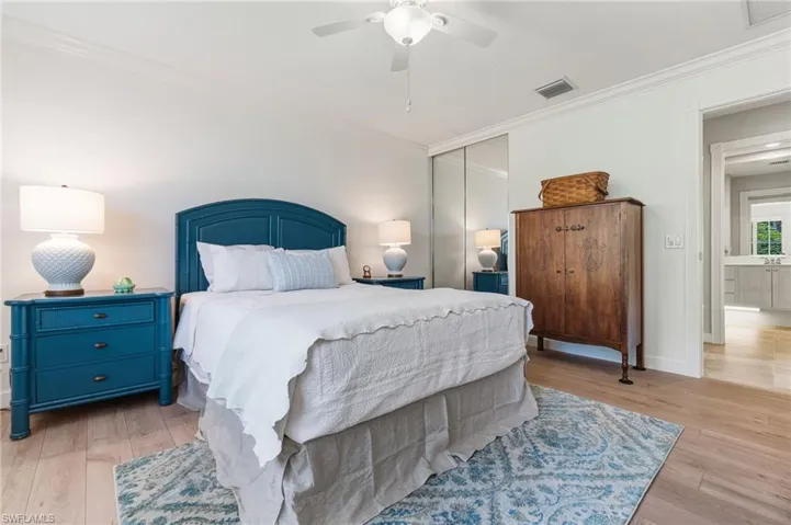 Bedroom with crown molding, light wood-style floors, a closet, and ceiling fan