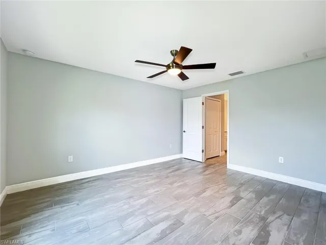 Unfurnished room with ceiling fan and hardwood / wood-style flooring