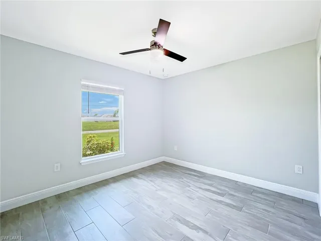 Empty room featuring hardwood / wood-style flooring and ceiling fan