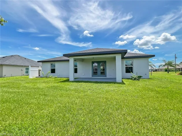 Rear view of house featuring a patio and a yard