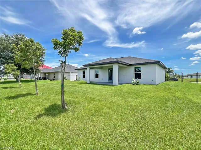 Back of house with a yard