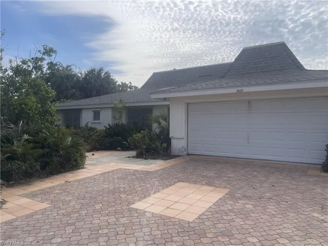 Single story home with a garage, a shingled roof, decorative driveway, and stucco siding