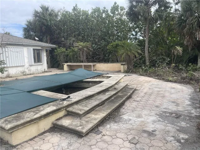 View of swimming pool with a patio area and a covered pool