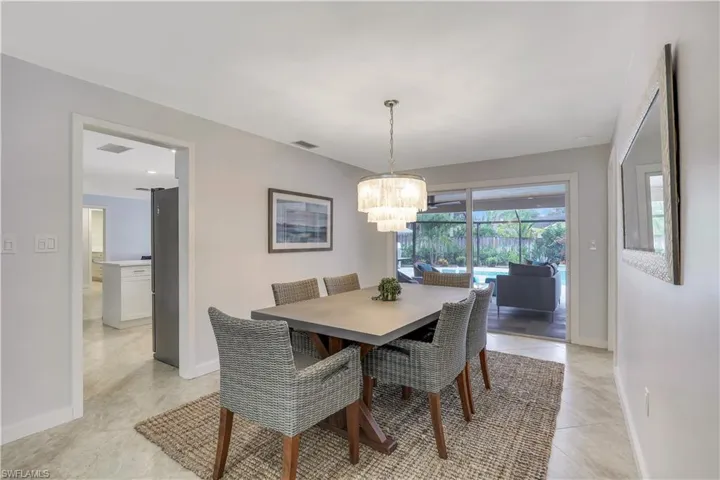 Tiled dining room with a chandelier