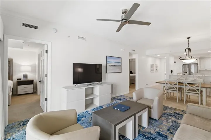 Living area with crown molding and ceiling fan