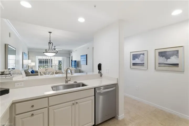 Kitchen with open floor plan, stainless steel dishwasher, light stone counters, pendant lighting, and recessed lighting