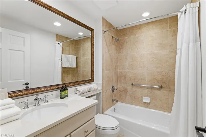 Full bathroom featuring vanity, shower / bath combo with shower curtain, and recessed lighting