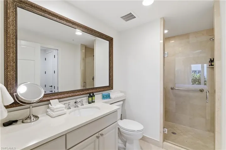 Bathroom featuring a stall shower, vanity, and recessed lighting