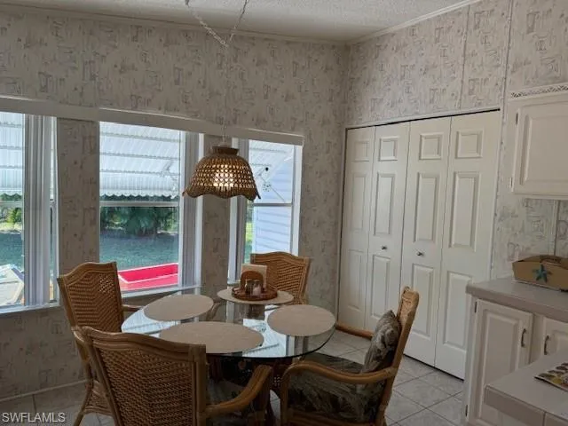 Dining area featuring light tile patterned floors and a textured ceiling