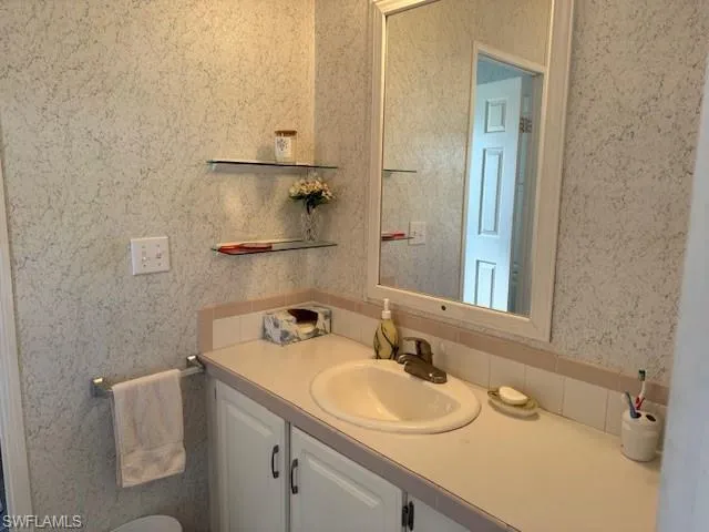 Bathroom featuring vanity and backsplash