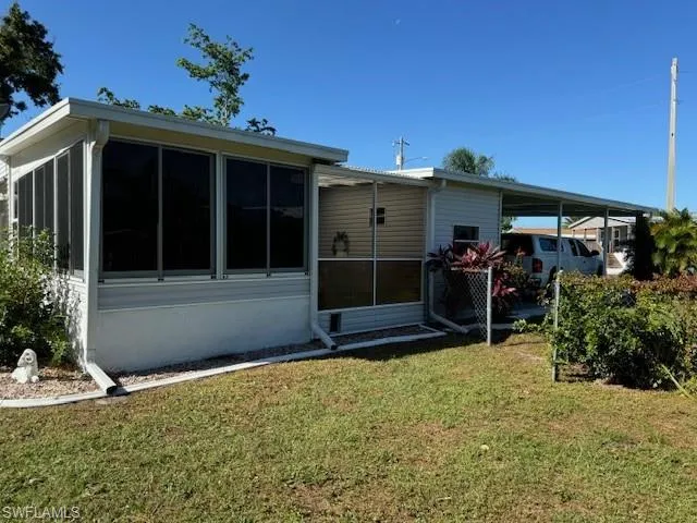 Rear view of property with a sunroom and a yard