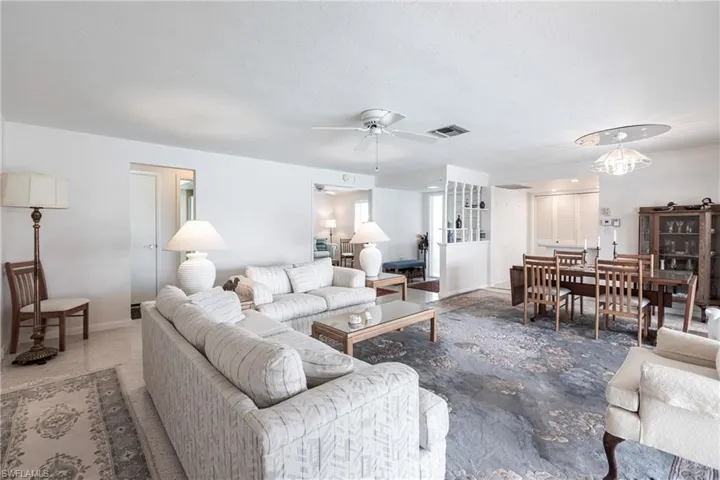 Living room with ceiling fan with notable chandelier
