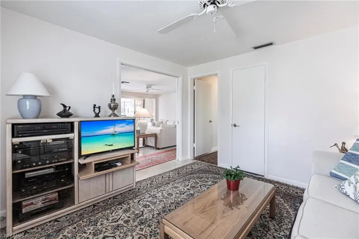 Carpeted living room featuring ceiling fan