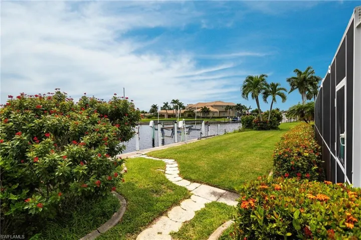 View of yard with a dock and a water view