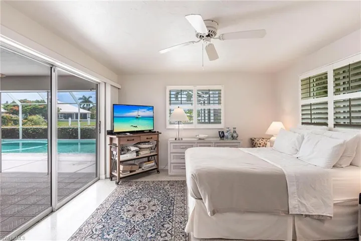 Bedroom with multiple windows, access to exterior, and ceiling fan