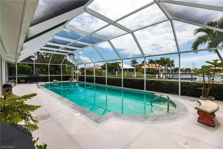 View of swimming pool featuring a patio and glass enclosure