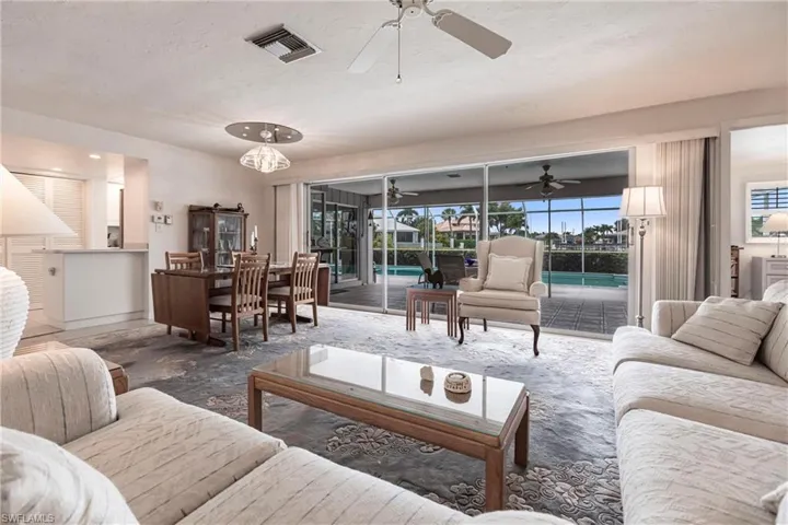 Living room with ceiling fan and a wealth of natural light