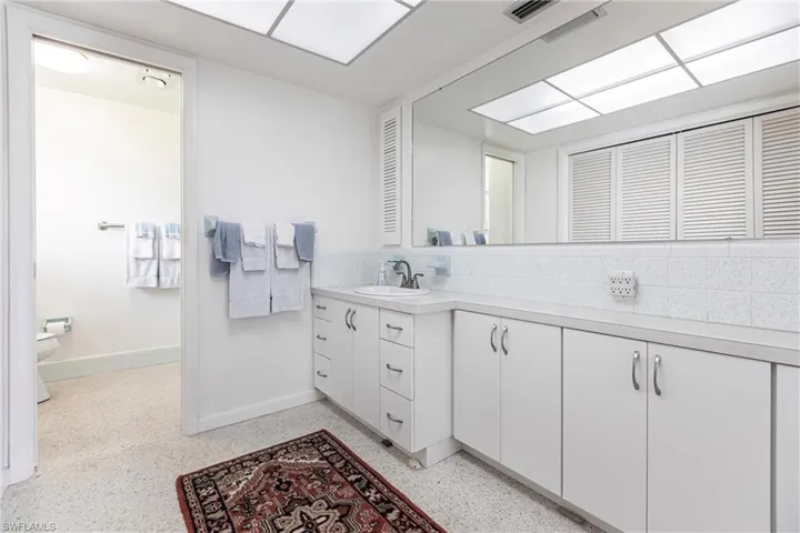 Bathroom with vanity, decorative backsplash, and toilet