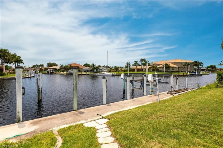 Dock area with a water view and a yard