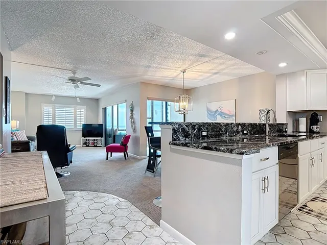 Carpeted living area with a textured ceiling, a ceiling fan, and track lighting