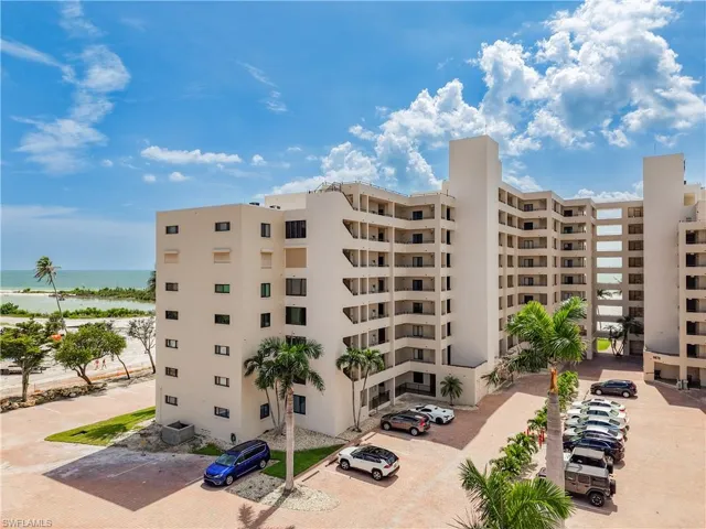 View of apartment building / complex with uncovered parking and a water view