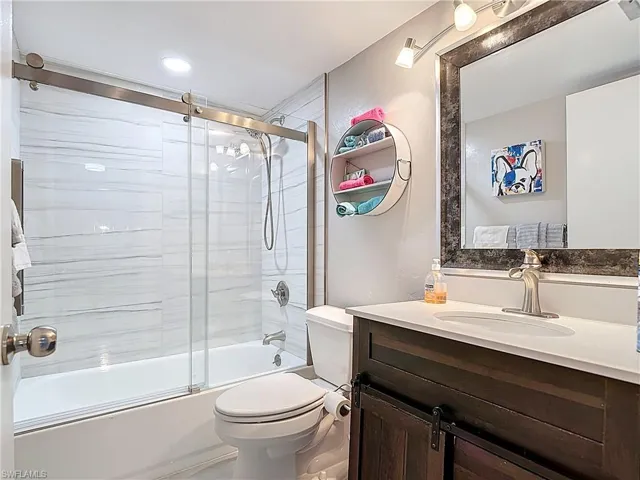Full bathroom featuring shower / bath combination with glass door and vanity