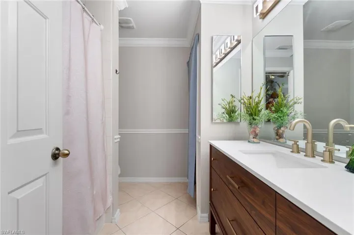 Bathroom featuring crown molding, vanity, and tile flooring