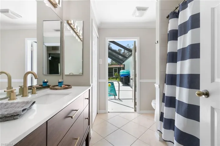 Bathroom featuring ornamental molding, tile patterned floors, vanity, and toilet