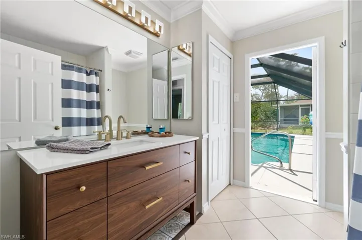 Bathroom featuring crown molding, vanity, and tile flooring