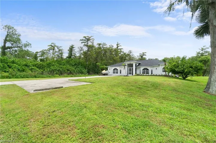 Ranch-style house featuring a front yard with extra parking