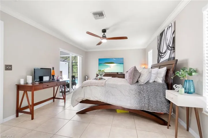 Tiled bedroom featuring crown molding and ceiling fan