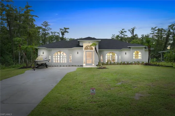 Ranch-style house featuring a front yard with extra parking