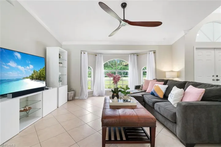Living room featuring ceiling fan, crown molding, and all tile floors
