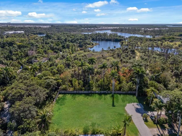 Aerial view of property's location featuring a forest and a nearby body of water