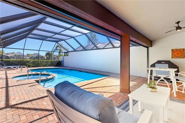 Relaxing pool / spa featuring a lanai, a patio area, outdoor dining area, and a sunroom