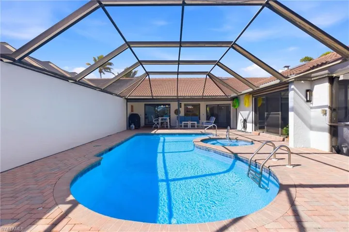 Integrated pool / spa with a sunroom, screen enclosure, and a patio