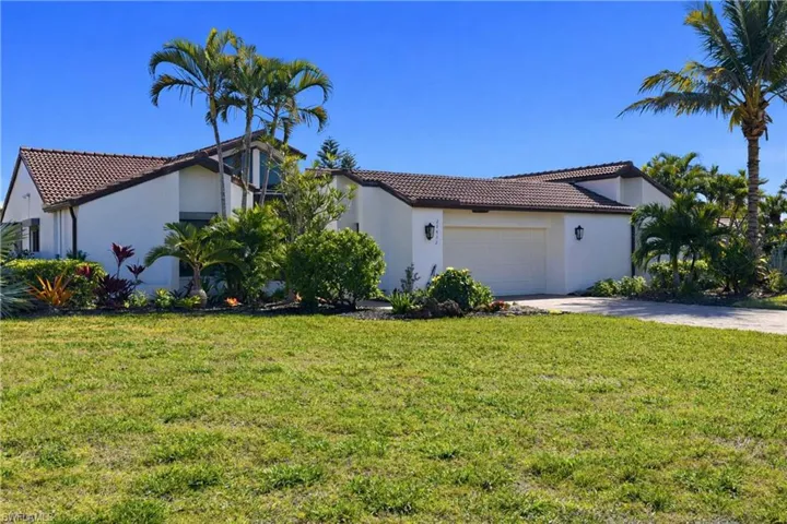 Mediterranean / spanish-style home with stucco siding, a tile roof, a front lawn, and concrete driveway