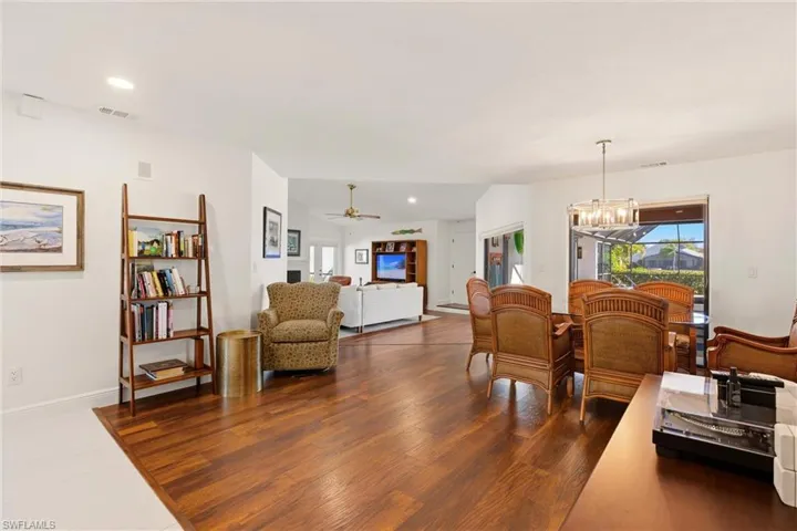 Dining space featuring hanging lights, a ceiling fan, healthy amount of natural light, and dark wood-style floors