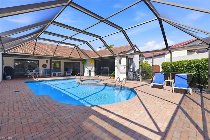 Integrated pool / hot tub with screen enclosure, a sunroom, and a patio