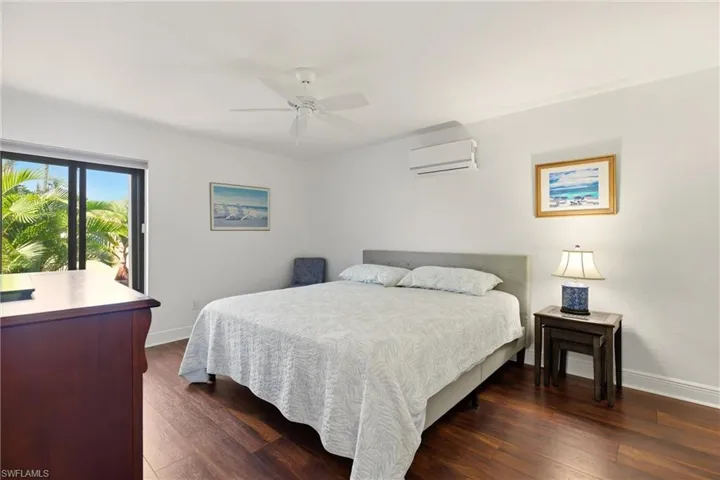 Bedroom with dark wood-style floors and a ceiling fan